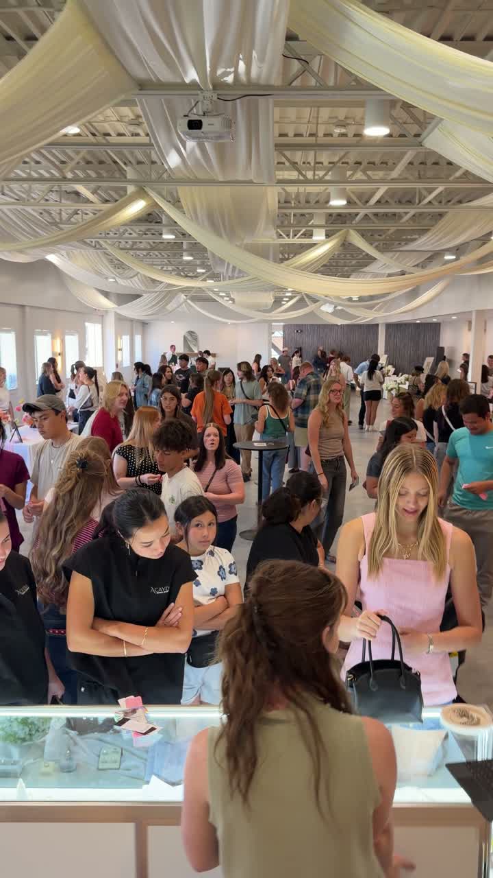 Guests leaning toward the jewelry display as a team member speaks with them